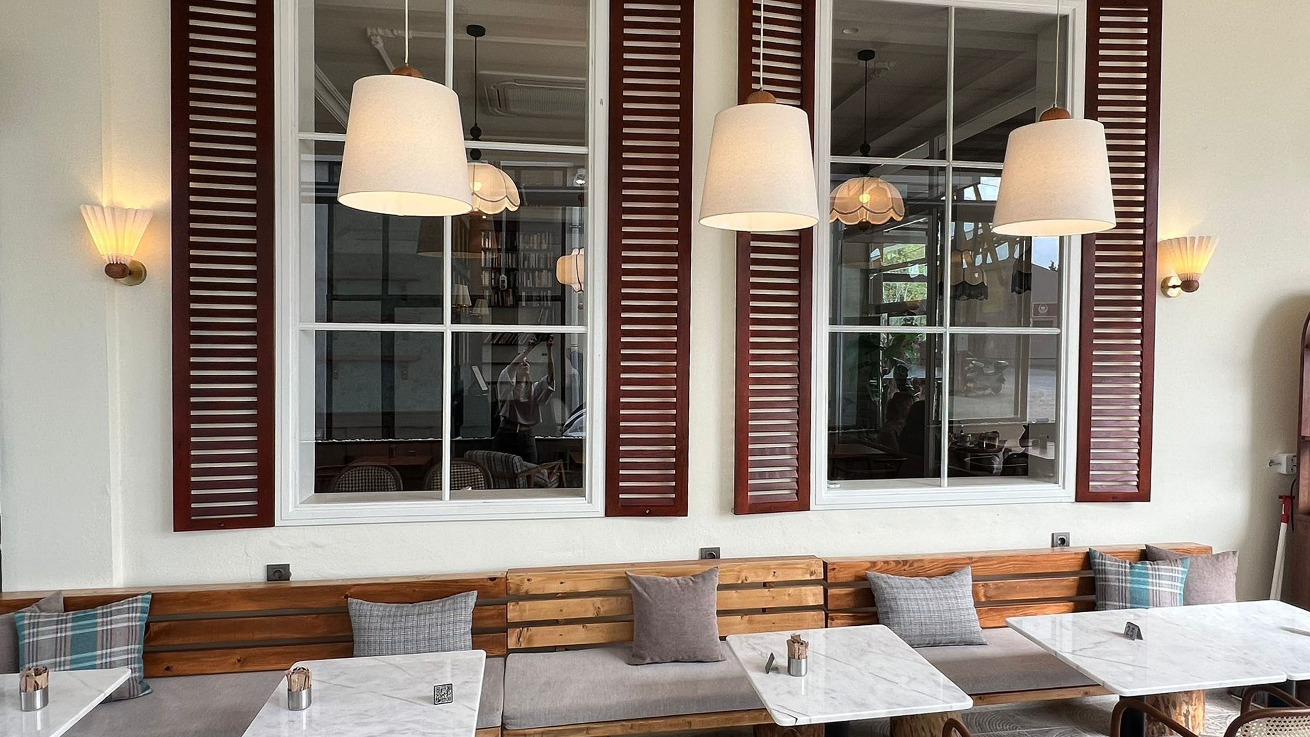 Kumaş başlıklı, pirinç ve ahşap detaylı duvar aplikleri modern iç mekanda